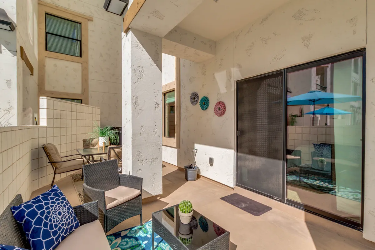 A tranquil interior lounge with comfortable seating, a cactus plant, decorative wall art, and a clear outdoor view. Sunlight pours in, and the setting supports both quiet relaxation and light socializing.